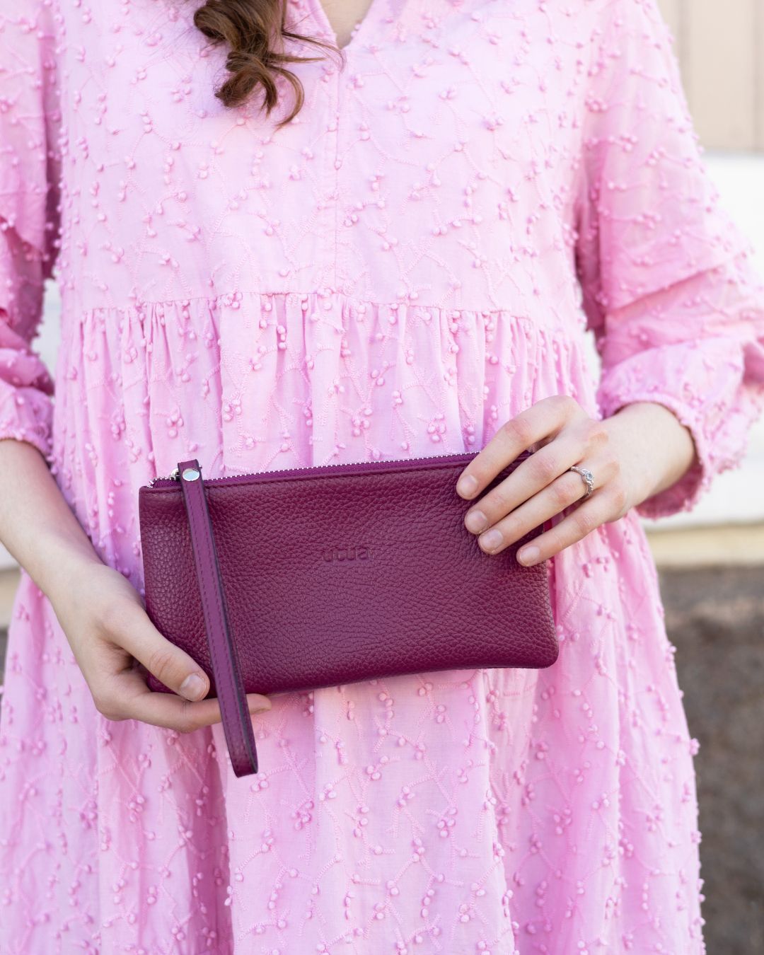 utua musta naava rannelaukku kadessa